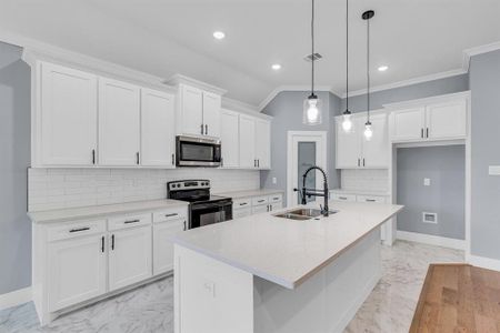 Kitchen with stainless steel appliances, a center island with sink, light tile flooring, and white cabinetry