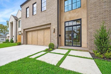 A contemporary path leads to the front door, flanked by manicured landscaping. The simple yet elegant design adds to the overall aesthetic of the home's entryway.