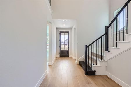 Entryway with light wood-type flooring and a high ceiling