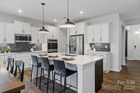 PHOTO REPRESENTATION ONLY. Kitchen of decorated model home. Finishes are different than shown. Refer to interior design selections for finishes. Refrigerator and double ovens not included.