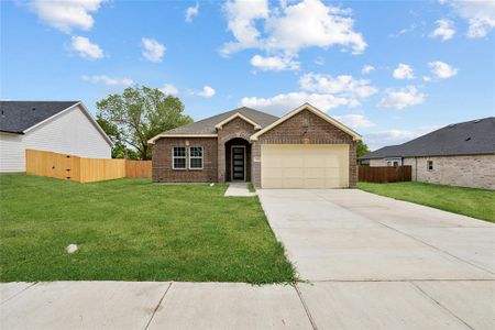 Ranch-style house featuring a garage and a front yard