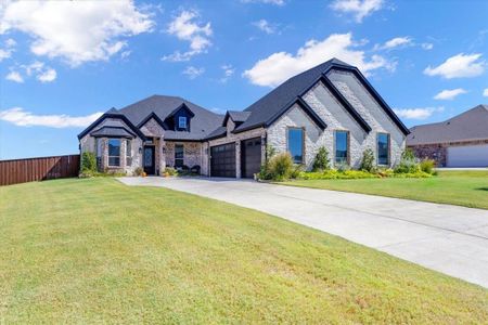 French country home featuring a front yard and a garage