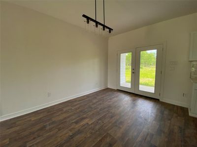 Unfurnished dining area featuring dark hardwood / wood-style floors and french doors