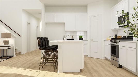Kitchen featuring white cabinetry, light hardwood / wood-style flooring, stainless steel appliances, backsplash, and a breakfast bar