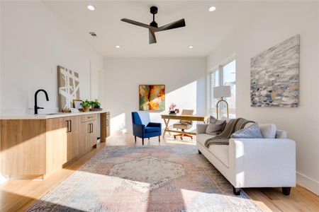 Living room featuring ceiling fan, light hardwood / wood-style flooring, and sink