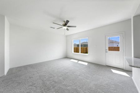 Carpeted living room featuring a wealth of natural light and ceiling fan