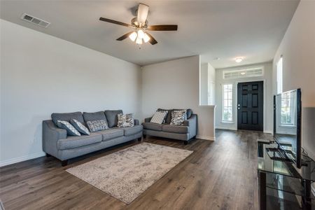 Living room with ceiling fan and dark hardwood / wood-style floors