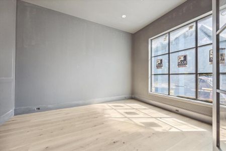 A a set of double doors lead you into the study. The study features wood paneling, a chandelier (to be installed) beautiful paint color, and a generously sized window with a view of the front yard.