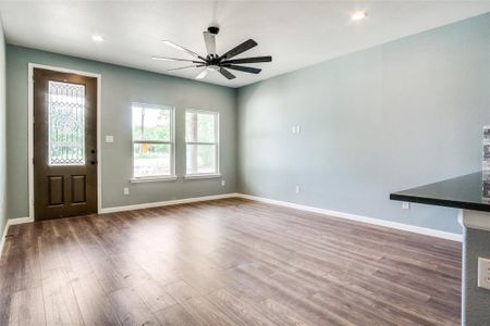 Unfurnished living room featuring ceiling fan and hardwood / wood-style flooring