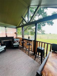 Sunroom with a fireplace, lofted ceiling, plenty of natural light, and a rural view