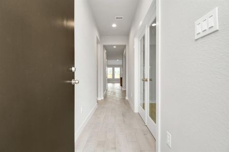 As you step into the threshold of this luxurious home, you'll soon be welcomed by an elegant glass door (to be installed), high ceilings, adorned with elegant wood-look tile flooring and oversized baseboards, and recessed lighting. Follow path of natural light from expansive windows ahead. Sample photo of completed home with similar floor plan. Actual colors and selections may vary.