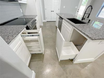 Kitchen featuring stone counters, white cabinetry, tasteful backsplash, sink, and appliances with stainless steel finishes