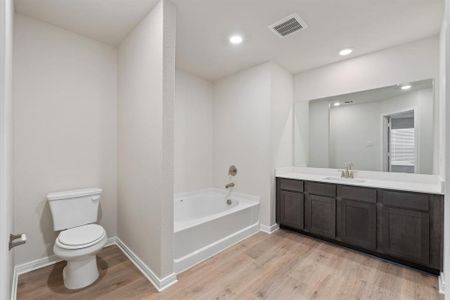 Bathroom with vanity, toilet, hardwood / wood-style flooring, and a bathing tub