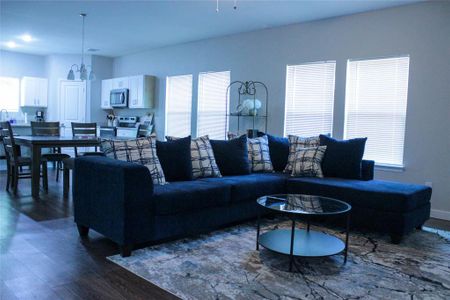 Living room featuring a chandelier, dark wood-type flooring, and a healthy amount of sunlight