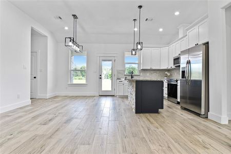 Another view of the island kitchen with windows to the backyard