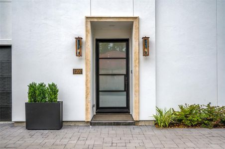 This stately front door, flanked by custom fixtures, greets you as you enter the home.