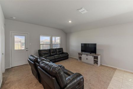 Tiled living room featuring vaulted ceiling