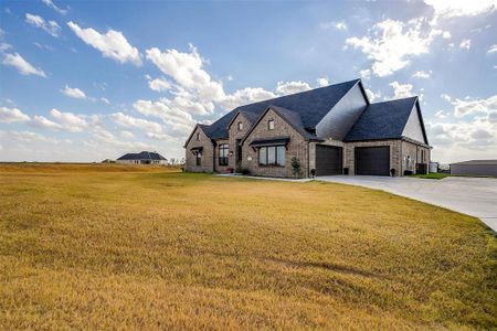 French provincial home with a front yard and a garage