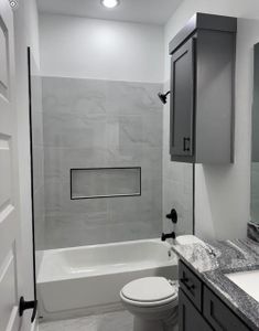 Full bathroom featuring vanity, toilet, and tiled shower / bath combo