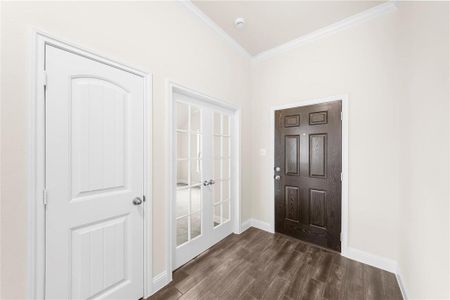 Foyer featuring crown molding and dark hardwood / wood-style flooring