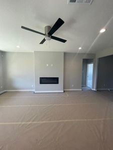 Unfurnished living room with a textured ceiling and ceiling fan