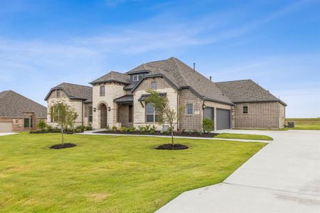 French country home with a garage and a front lawn