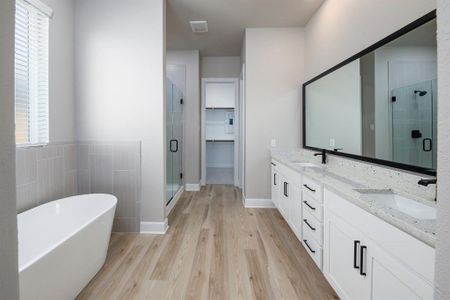 The master bedroom has an array of enviable features including an impressive bathroom with a standalone tub, a walk-in shower and sizable walk-in closet.