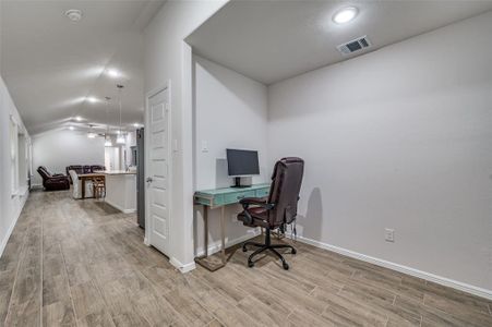 Office featuring ceiling fan, lofted ceiling, and light hardwood / wood-style floors