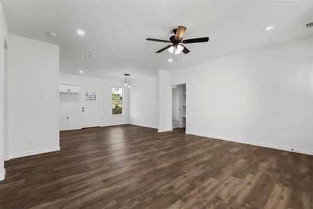 Unfurnished living room featuring dark hardwood / wood-style floors and ceiling fan