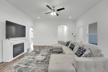 Living room featuring ceiling fan and dark hardwood / wood-style flooring