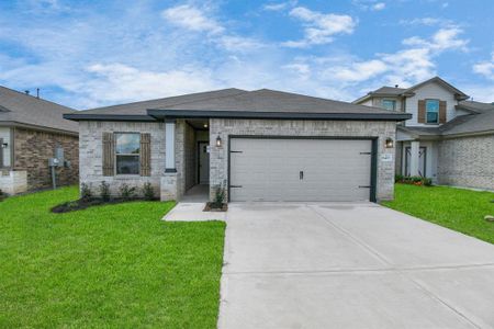 This charming home features a brick exterior with wood accents, a spacious two-car garage, and a welcoming covered entry. The manicured lawn and clean concrete driveway add to its inviting curb appeal, while modern touches and a neutral color palette create a timeless look.