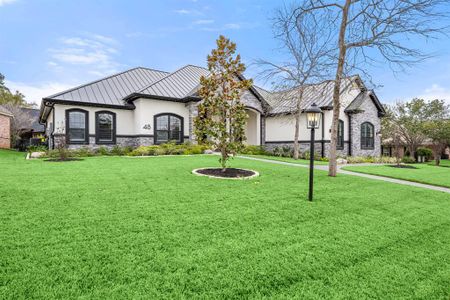 Metal roof and professional landscaping with over 10 types of plants and 4 types of trees. Lake Conroe is behind the houses on the opposite street