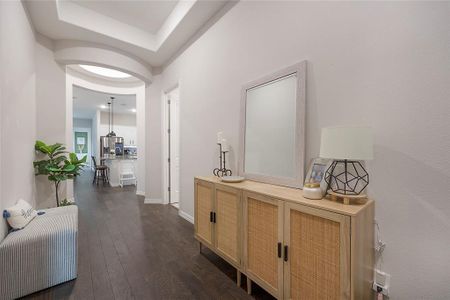 Hallway featuring dark hardwood / wood-style flooring and a raised ceiling