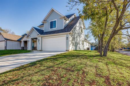 View of front facade featuring a front yard and a garage