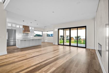 Unfurnished living room featuring light hardwood / wood-style floors and sink