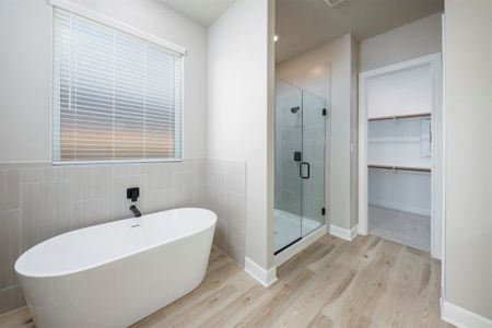 Welcome to the en-suite bathroom, featuring a separate tub and shower combo for added luxury. Whether indulging in a soothing bath or refreshing shower, this well-appointed space offers the perfect retreat after a long day."