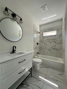 Full bathroom featuring tiled shower / bath, tile flooring, toilet, and vanity