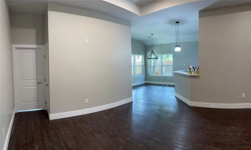 Spare room with dark wood-type flooring and a chandelier