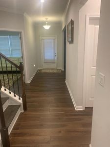 Corridor featuring ornamental molding and dark wood-type flooring