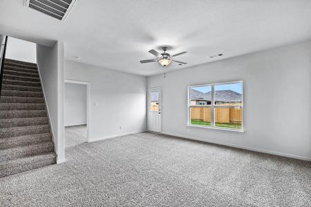 Unfurnished living room featuring carpet flooring and ceiling fan