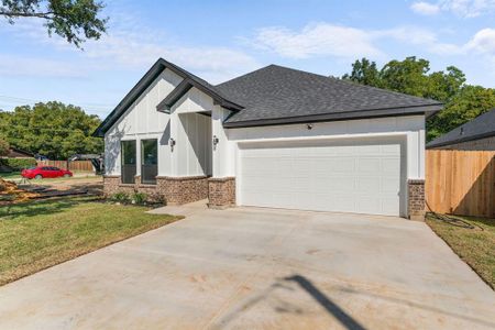 View of front of home with a front lawn and a garage