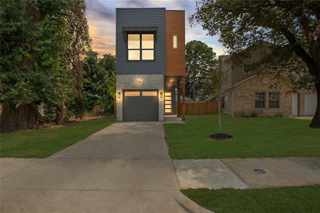 View of front of property with a garage and a yard