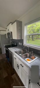 Kitchen featuring white cabinets, appliances with stainless steel finishes, sink, dark hardwood / wood-style floors, and decorative backsplash