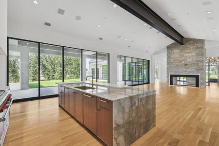 Kitchen with decorative backsplash, premium range hood, green cabinets, light hardwood / wood-style floors, and double oven range