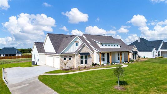 View of front of house featuring cooling unit, a garage, and a front lawn