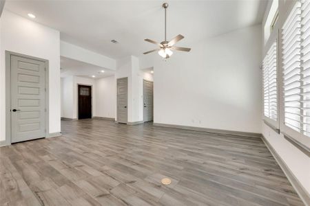 Unfurnished living room with light wood-type flooring and ceiling fan