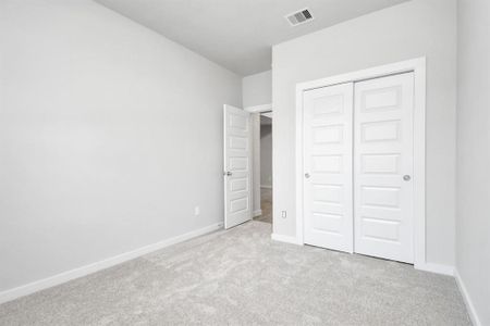 Quietly nestled in front of the home is a guest suite. Featuring plush carpet, custom paint and large window with privacy blinds. Sample photo of completed home with similar floor plan. As-built interior colors and selections may vary