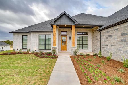 Front of home includes solid cedar beams, brick and stone.