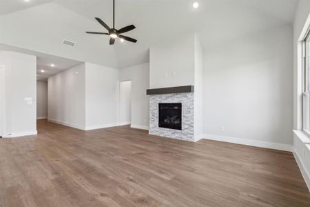 Unfurnished living room with ceiling fan, high vaulted ceiling, hardwood / wood-style flooring, and a fireplace