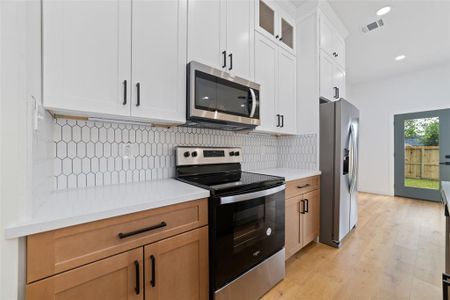 The custom tile backsplash not only protects against splashes and stains but also adds a touch of decorative charm and texture, making the kitchen both practical and visually captivating.
